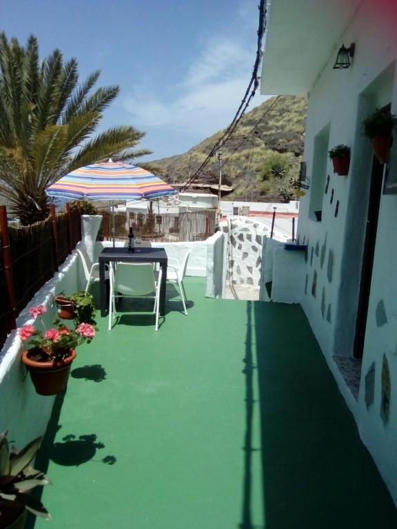 a patio with a table and an umbrella at Casa Faican in Agaete