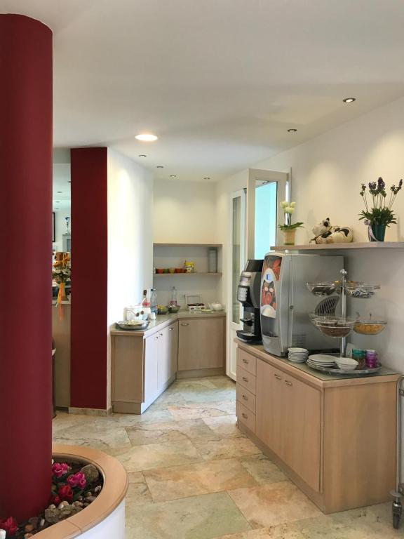a large kitchen with a counter and a kitchen with at Hotel Aurora in San Vincenzo