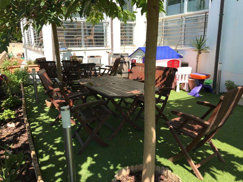 a wooden table and chairs under a tree at Hotel Aurora in San Vincenzo