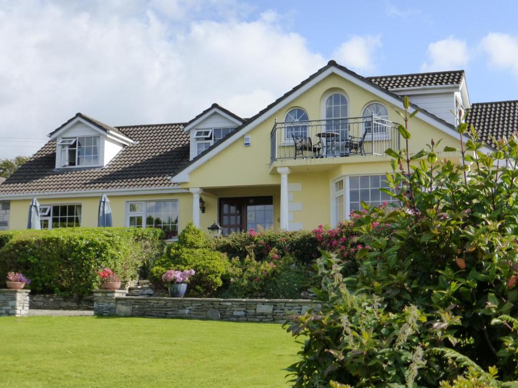 a yellow house with a yard at Oakfield in Kenmare