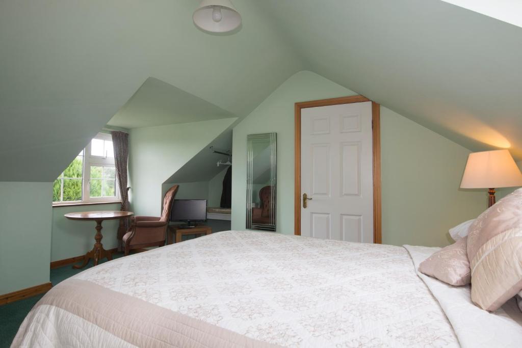 a bedroom with a white bed and a window at Oakfield in Kenmare