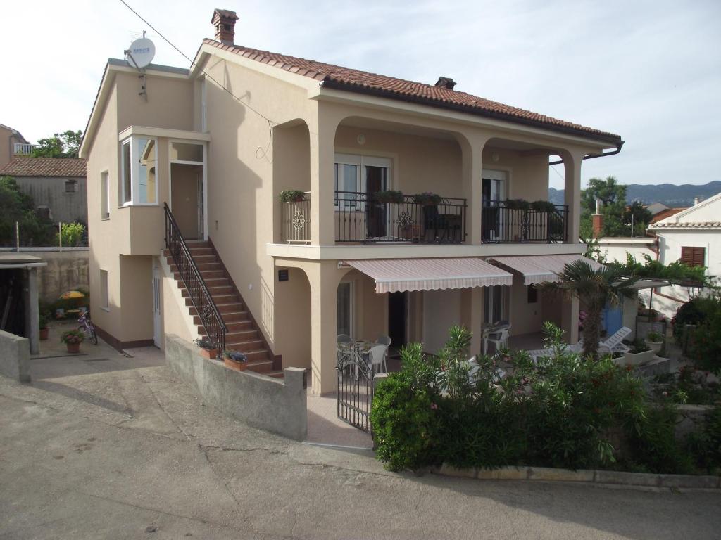 een wit huis met een balkon en een veranda bij Apartments Dajana Silo in Šilo