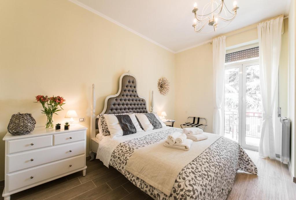 1 dormitorio con 1 cama, vestidor y ventana en Tivoli Charming Houses - Domus Aefula and Domus Albula, en Tívoli