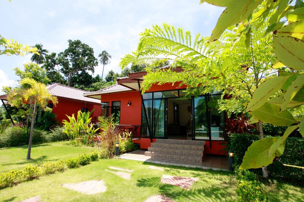 a red house with glass doors and a yard at Saree Lagoon Villa Koh Samui in Lipa Noi