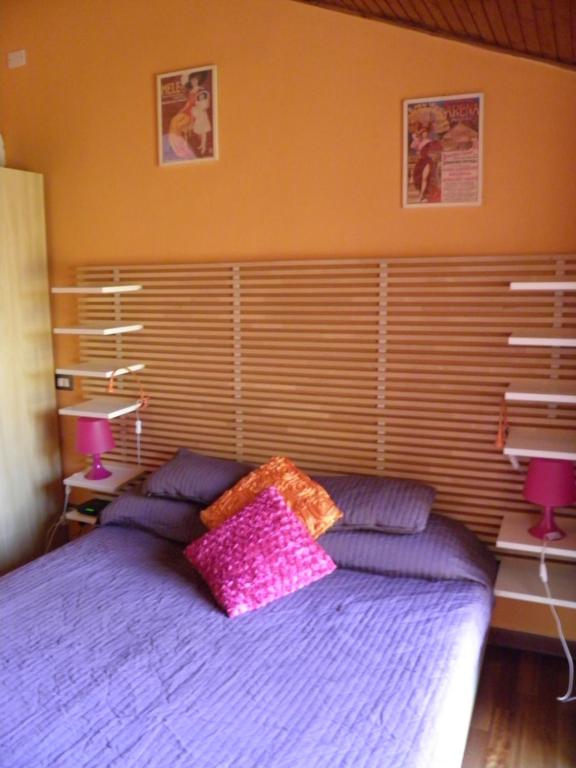 ミラノにあるIl Nido Sul Tetto A Milanoのベッドルーム1室(紫色のベッド1台、枕2つ付)