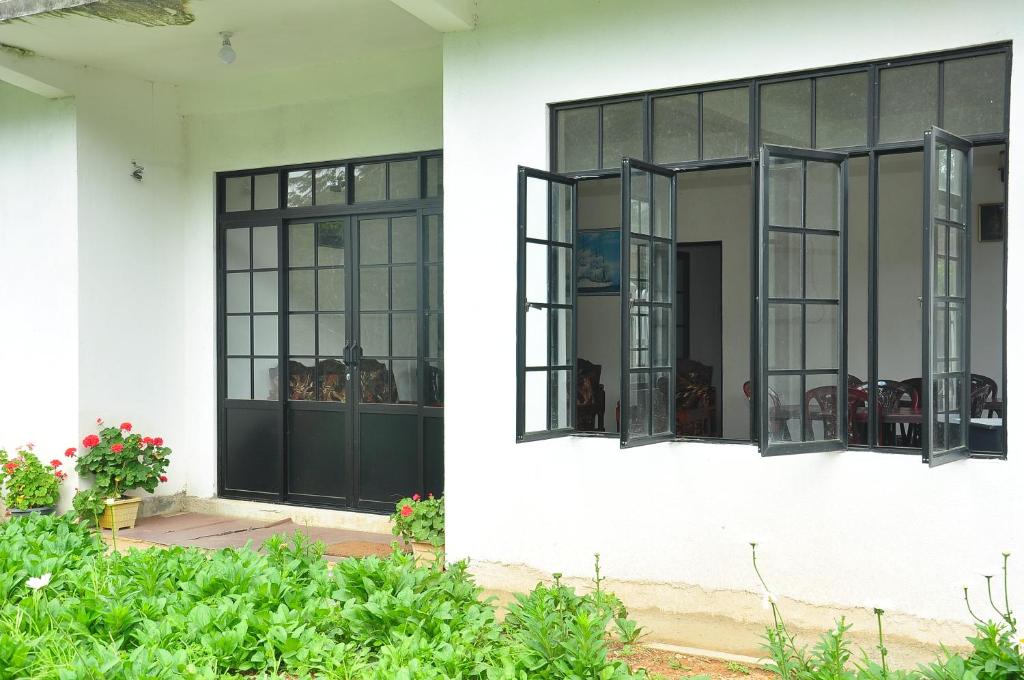 努沃勒埃利耶的住宿－Akiko Rest，两扇窗户,位于白色的黑色房子上