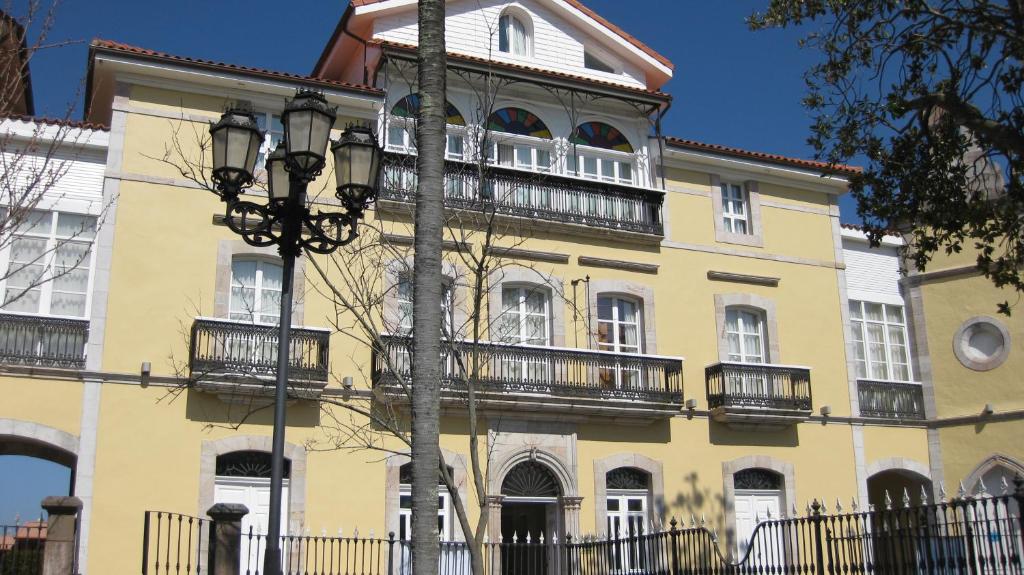 a yellow building with balconies and a street light at Hotel Palacio de Garaña in Garaña
