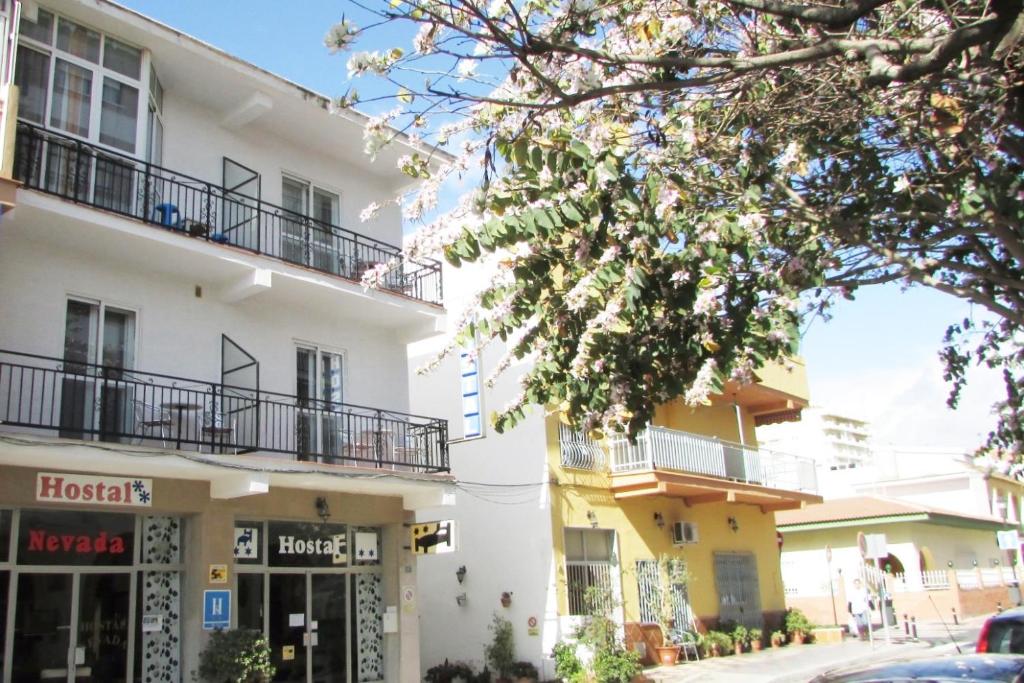 un edificio blanco con balcones en una calle en Hostal Nevada, en Fuengirola