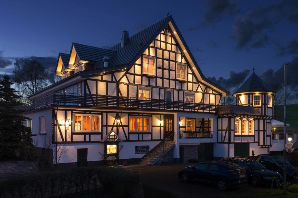 a large house with a car parked in front of it at Landhotel Repetal in Attendorn