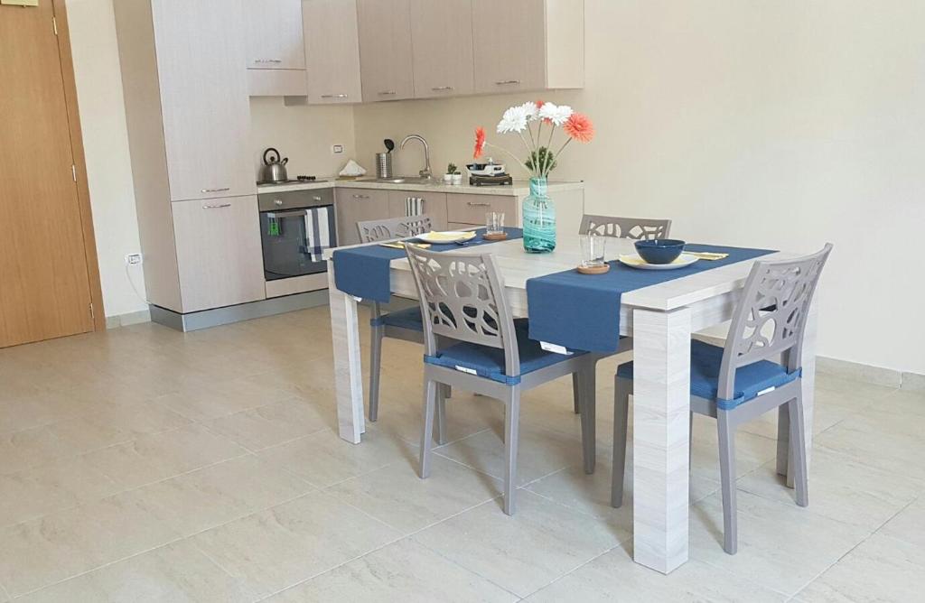 una cucina con tavolo, sedie, tavolo blu e sedie a sdraio di Don Marino Residence a Trani