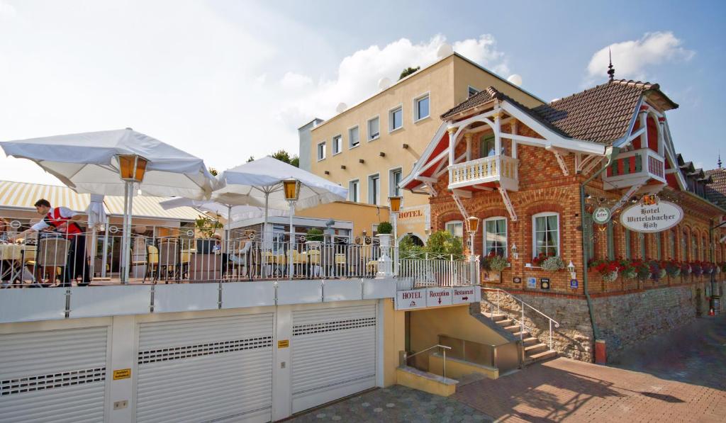 ein Gebäude mit Tischen und Stühlen auf einem Balkon in der Unterkunft Hotel Wittelsbacher Höh in Würzburg