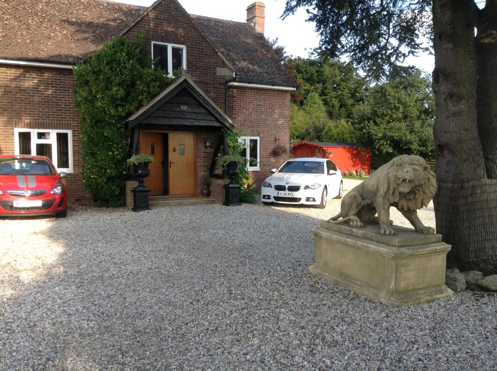 una statua di leone davanti a una casa di B&B Dorwyn Manor ad Avebury