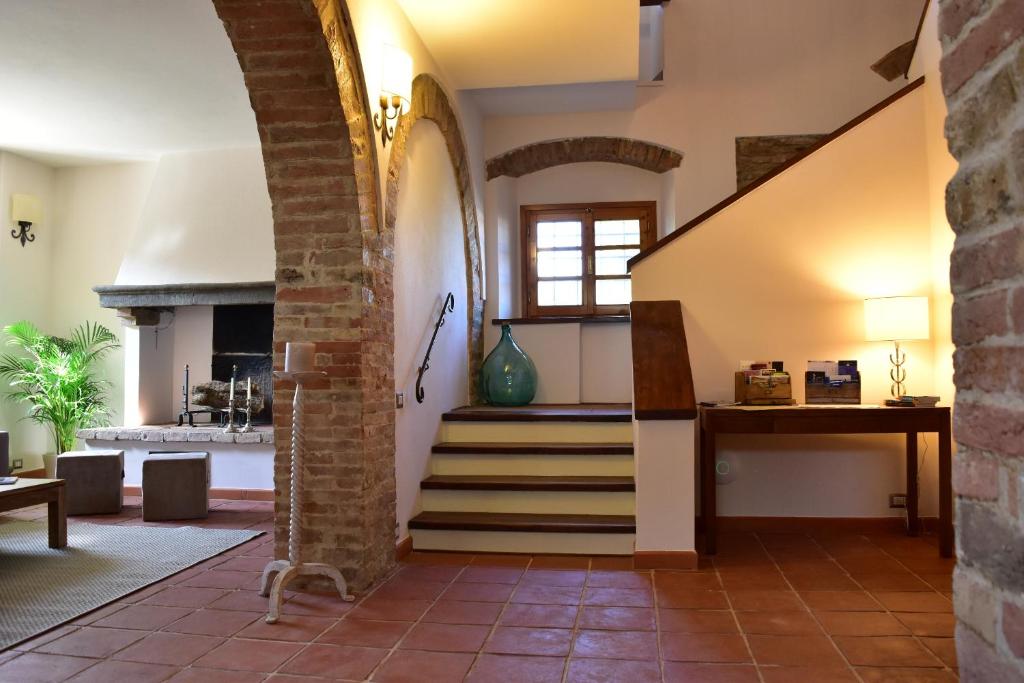 a living room with a staircase and a brick wall at Villa San Michele in Barberino di Val dʼElsa