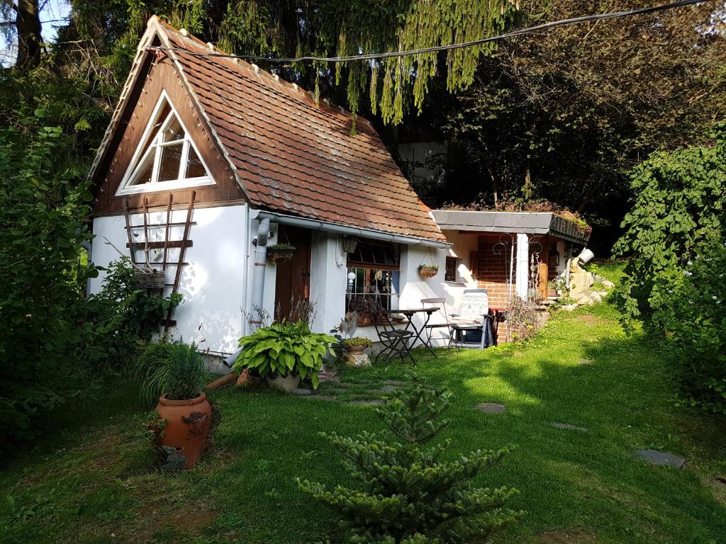 una pequeña casa blanca con un patio de césped en Wohnen im Hühnerhaus en Thale