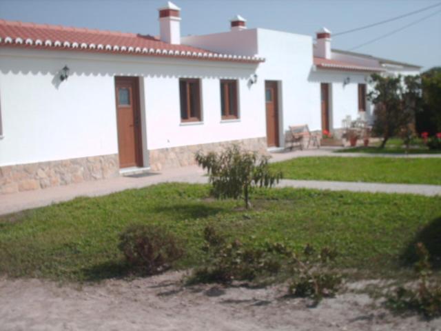 a white house with a grass yard and a house at Quinta da Bunheira in Rogil