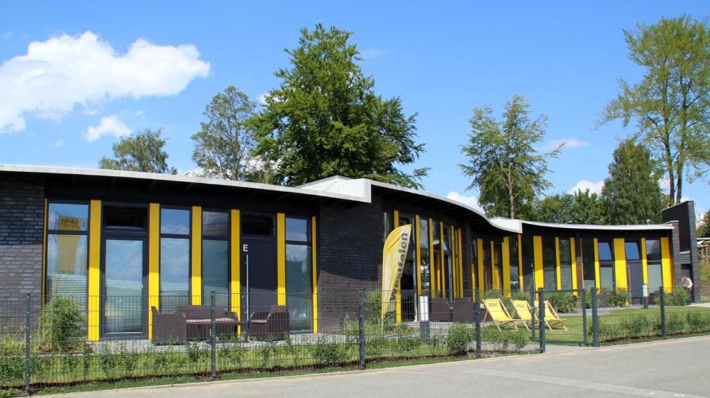 ein Gebäude mit gelben Türen und Fenstern auf einer Straße in der Unterkunft ADAC Campingplatz in Möhnesee