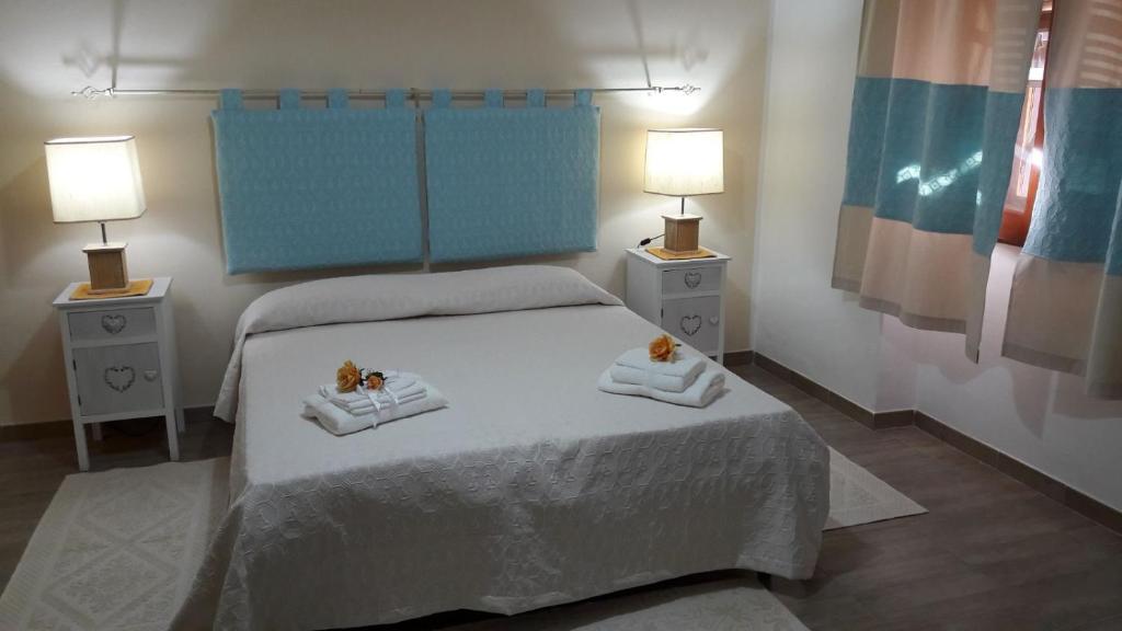 ポルト・トッレスにあるCamere Vacanze Acqua Chiaraのベッドルーム1室(タオル2枚、ランプ2つ付)