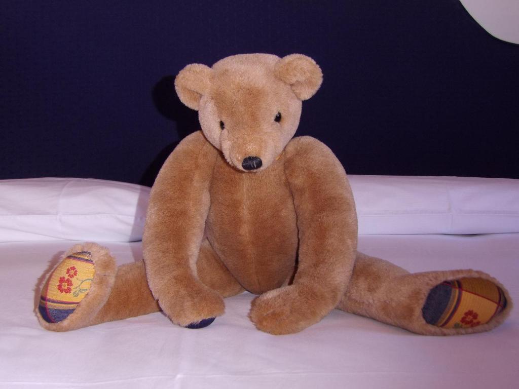 a brown teddy bear sitting on a bed at Casa Dell'Orso in Roccaraso