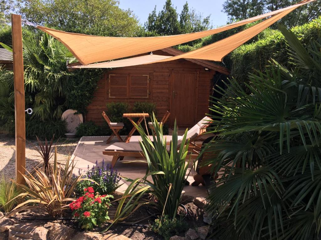 eine Terrasse mit einem Zelt und einem Tisch und einigen Pflanzen in der Unterkunft chalet golfe de st tropez in Grimaud