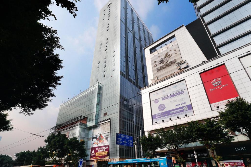 un grand bâtiment avec des panneaux sur son côté dans l'établissement Boman Holiday Apartment Bei Jing lu Jie Deng Du Hui Branch, à Canton
