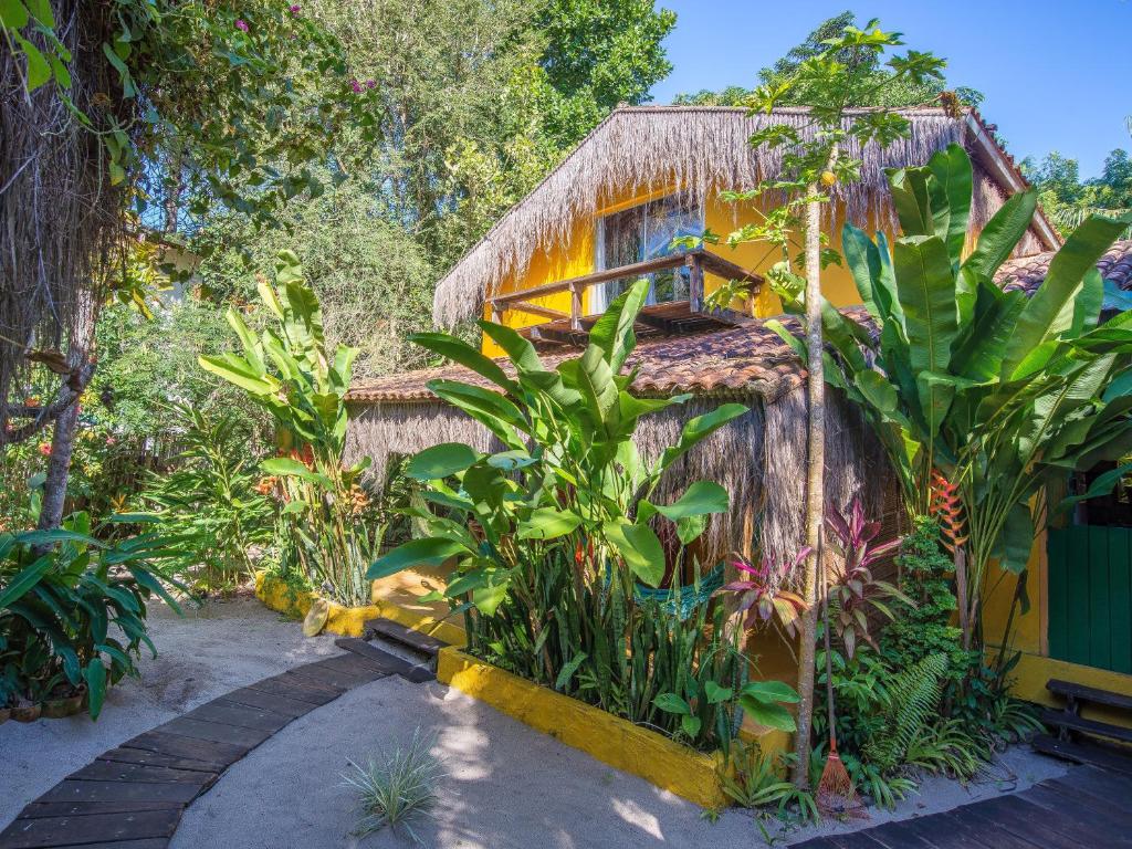dom z kupą roślin przed nim w obiekcie Pousada Canoa Nativa w mieście Ilha de Boipeba