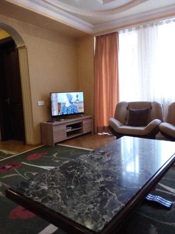 un salon avec une table et une télévision dans l'établissement appartments in Batumi, à Batoumi