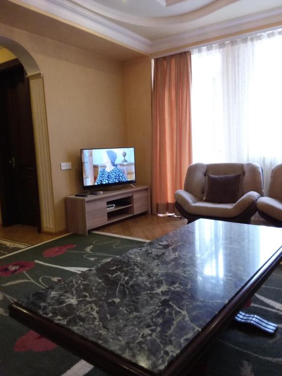 a living room with a table and a television at appartments in Batumi in Batumi