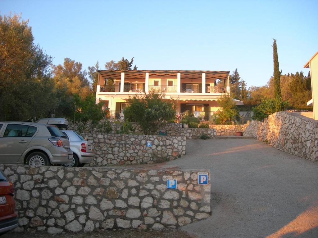 ein Haus mit einer Steinmauer und einem Auto vor dem Haus in der Unterkunft To Ampelaki in Tsoukaladhes