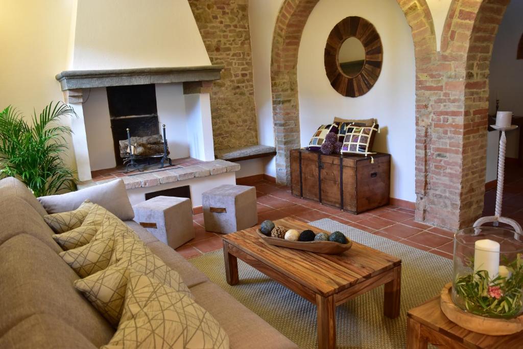 a living room with a couch and a fireplace at Villa San Michele in Barberino di Val dʼElsa