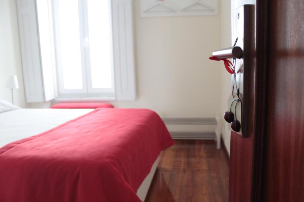 um quarto com uma cama vermelha e uma janela em Huga Home em Lamego