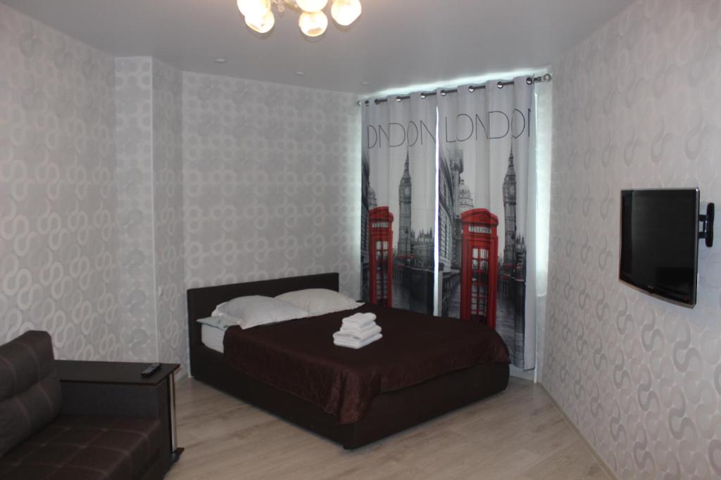 アルハンゲリスクにあるKvartira v centre Obvodnyy 29のベッドルーム1室(ベッド1台付)、赤い電話ブースが備わります。