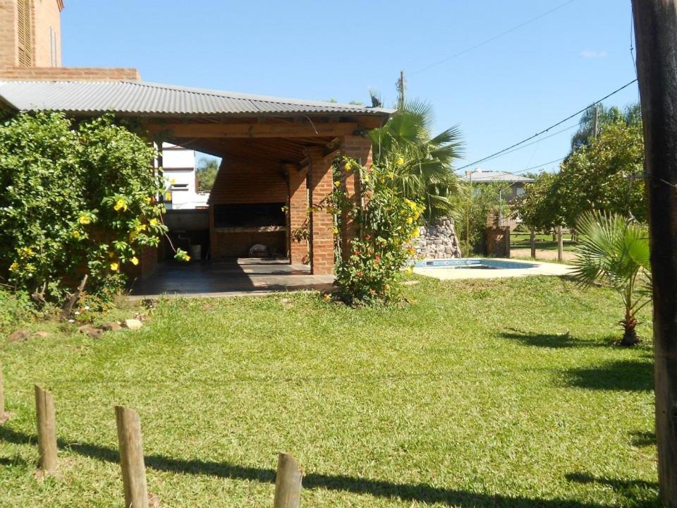 a brick house with a fence in a yard at Angeluz Paso De La Patria in Paso de la Patria