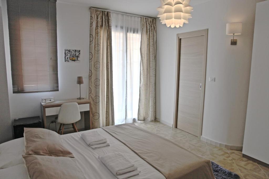 een slaapkamer met een bed, een bureau en een raam bij CasaLeo in Campofelice di Roccella