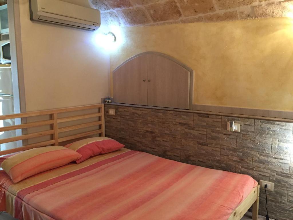 a bedroom with a bed and a brick wall at Sea Home 2 in Monopoli