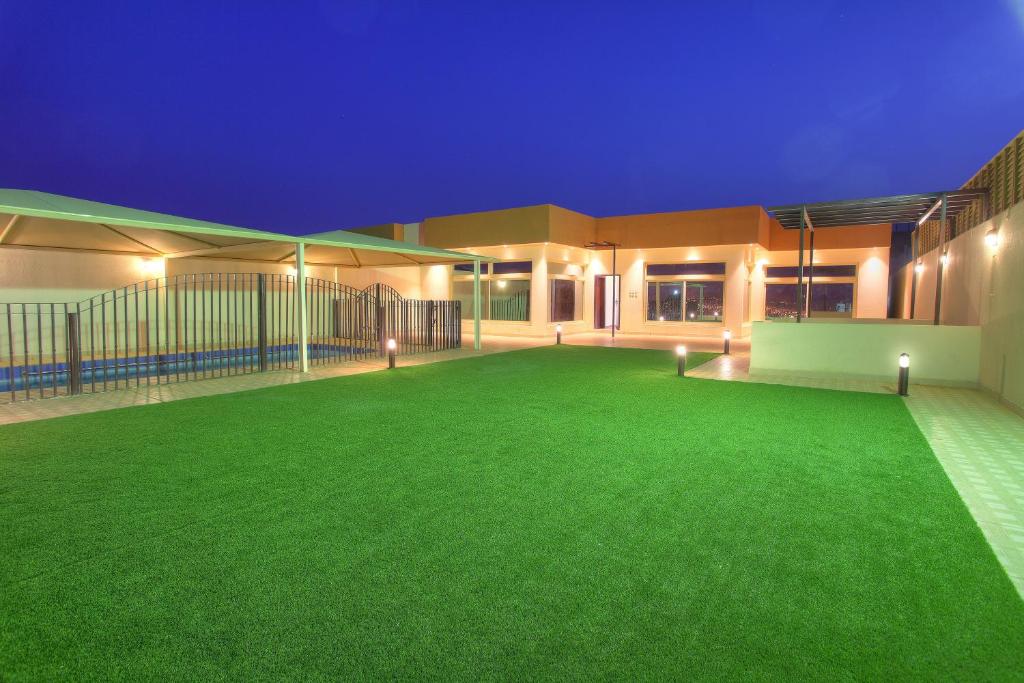 a building with a green lawn in front of it at Star City Chalets in Az Zulfi