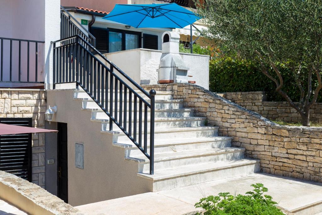 a staircase with a blue umbrella on top of it at Monte & Paradiso in Pula