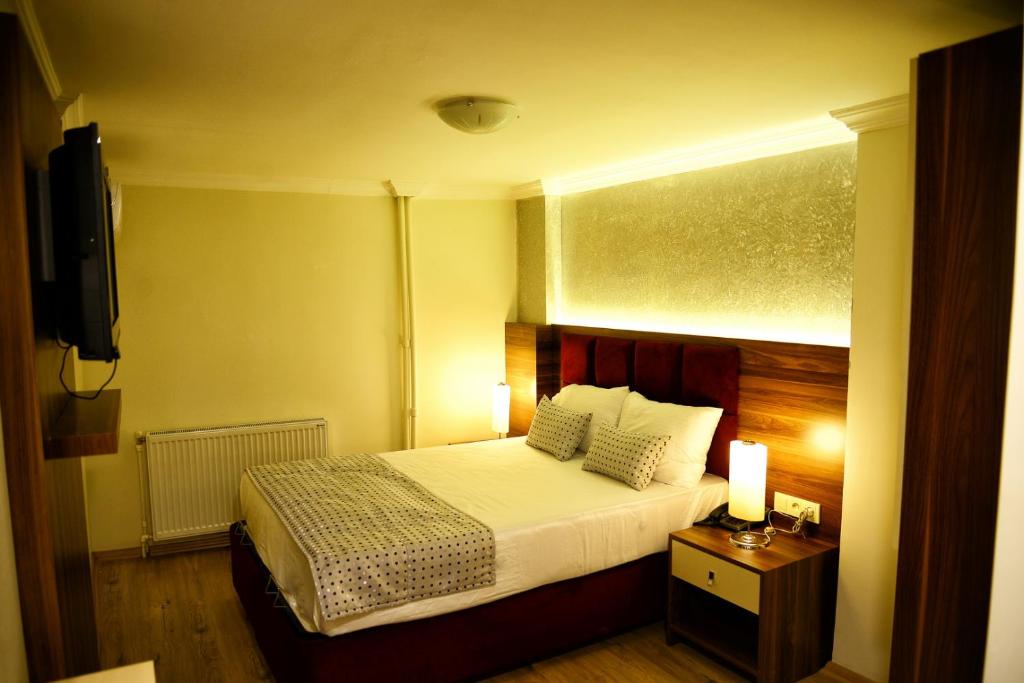 a hotel room with a bed and a television at Laleli Hotel Izmir in Izmir