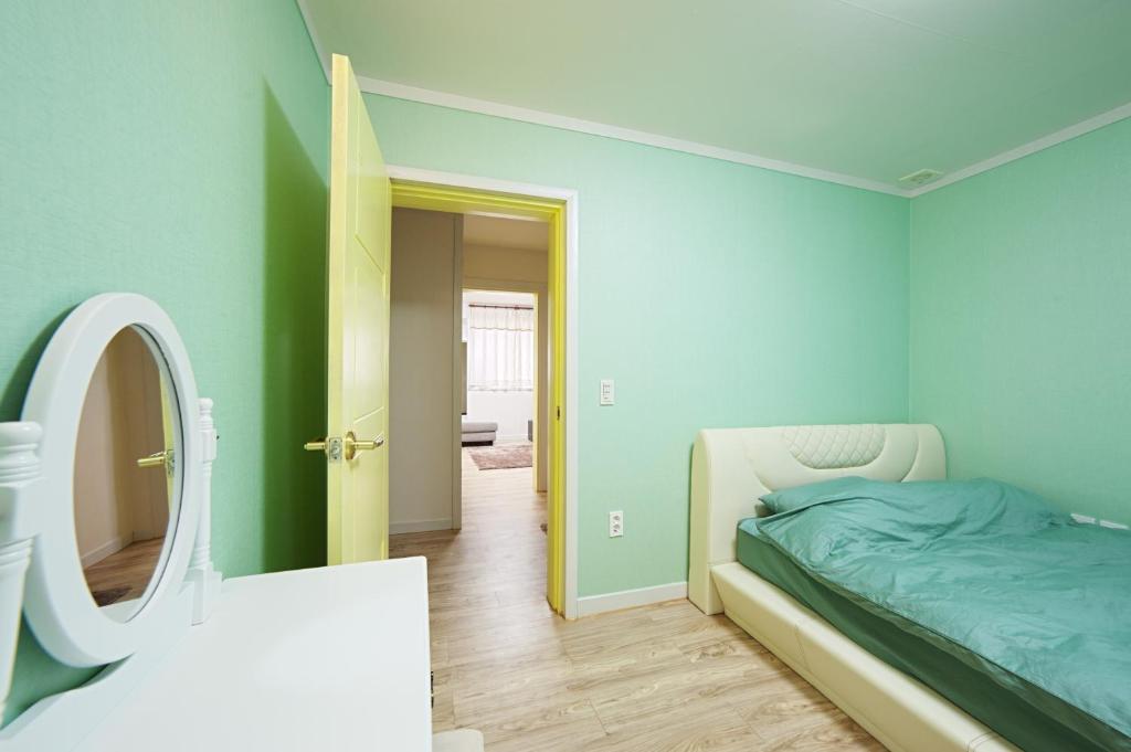 - une chambre avec un lit et un miroir dans l'établissement Namhae Frankfurt Pension, à Namhae