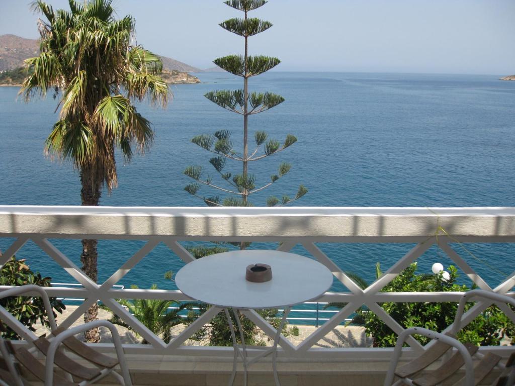 una mesa en un balcón con vistas al océano en Melas Apartments, en Agios Nikolaos