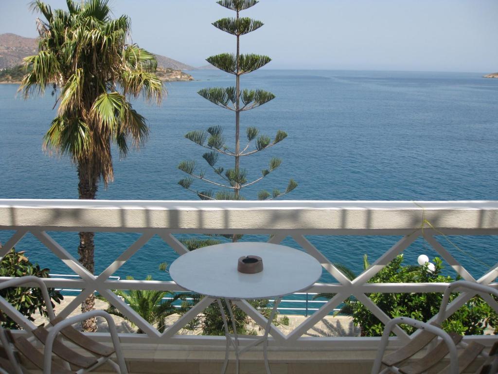 a table on a balcony overlooking the ocean at Melas Apartments in Agios Nikolaos