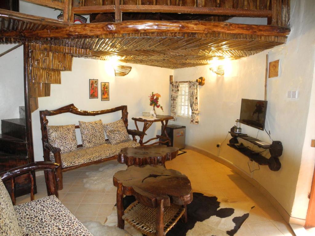ein Wohnzimmer mit einem Sofa und einem TV in der Unterkunft Karen Little Paradise in Nairobi