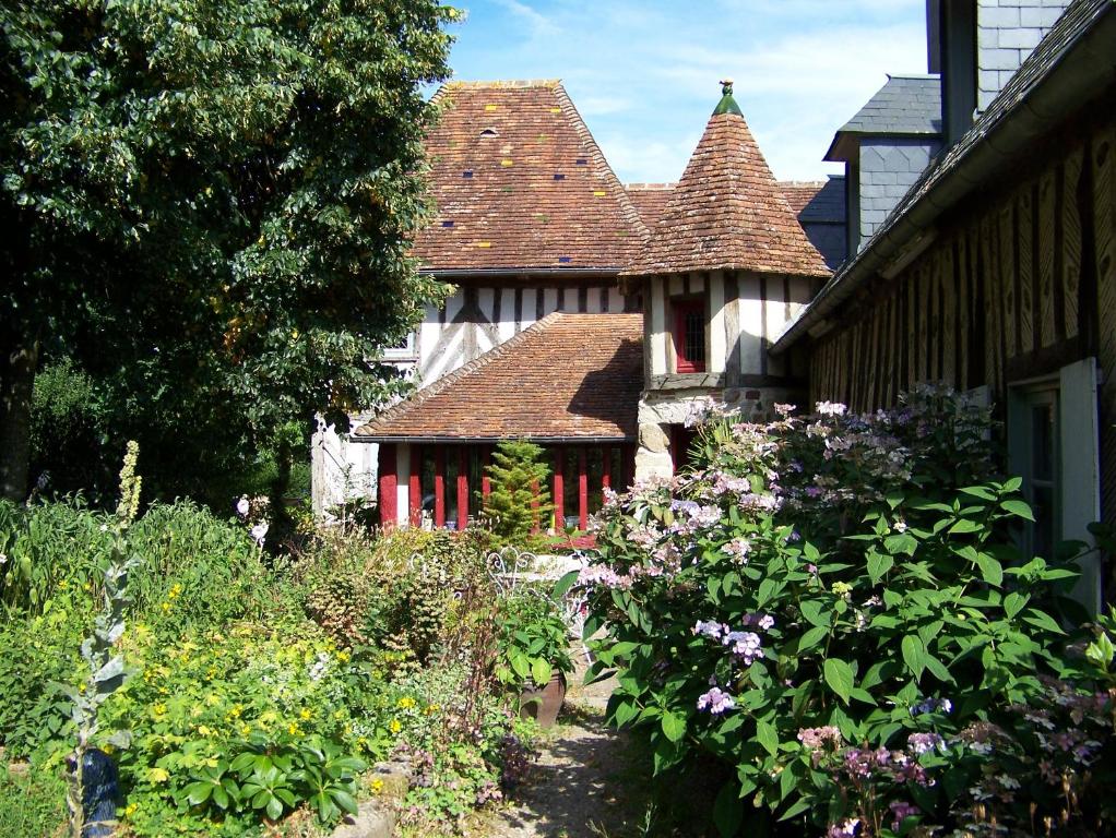 uma casa com um jardim com flores em frente em Le Pommenial de la Hérissonnière em Saint-Aubin-de-Bonneval