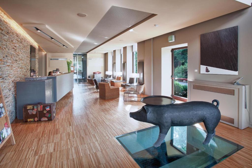 a living room with a statue of a cow on the floor at Alter Hotel in Barge