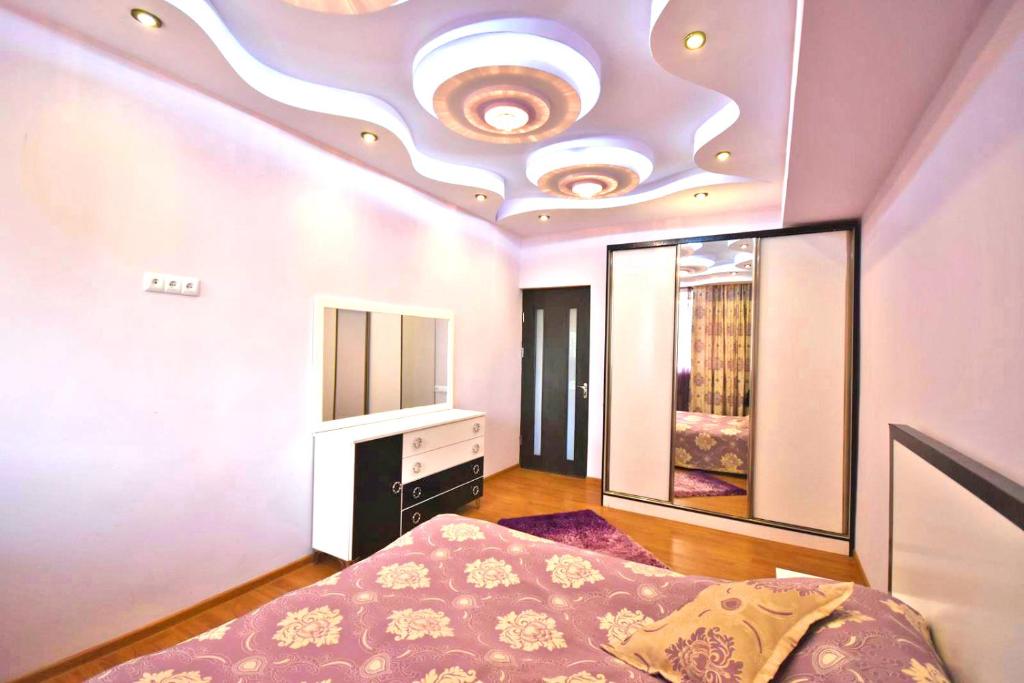 a bedroom with a bed and a ceiling with a mirror at Three Rooms Center Yerevan 6 in Yerevan