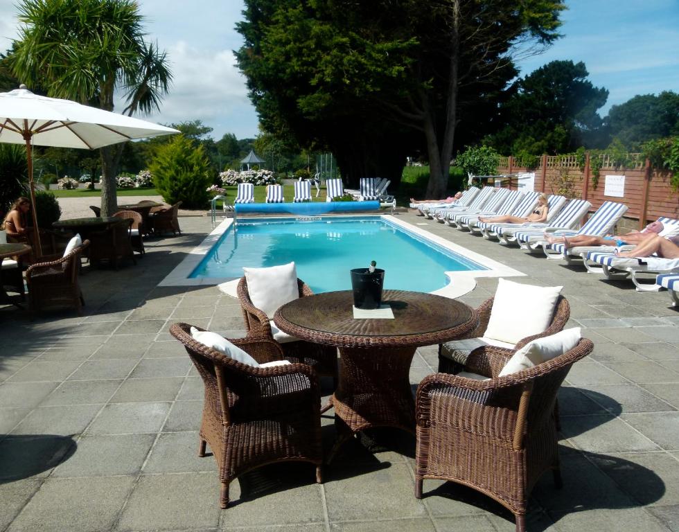 a table and chairs next to a swimming pool at Beachcombers Hotel in Saint Helier Jersey