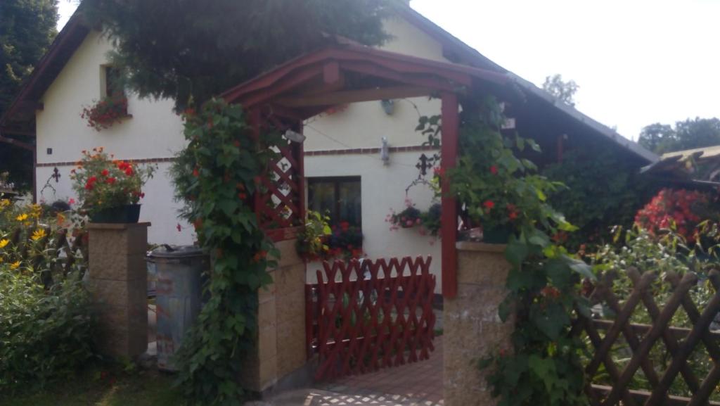 ein Haus mit einem roten Tor und einem Zaun in der Unterkunft U Tří Koček in Jablonné v Podještědí