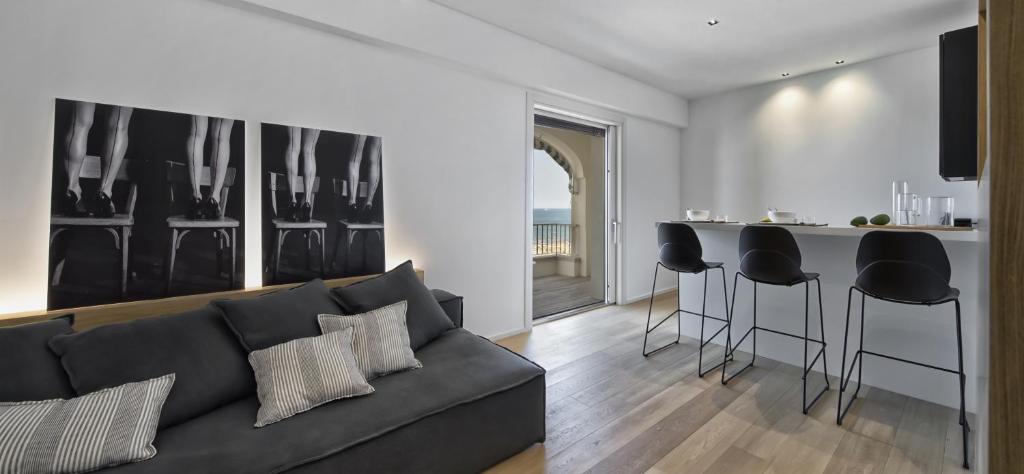 ein Wohnzimmer mit einem Sofa und einer Küche in der Unterkunft Luxury Suites Collection - Frontemare Viale Milano 33 in Riccione
