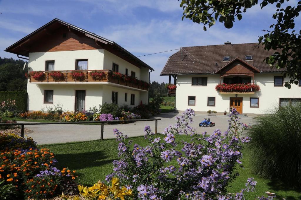 ein paar Gebäude mit Blumen im Hof in der Unterkunft Familienparadies Zeislerhof in Glanegg