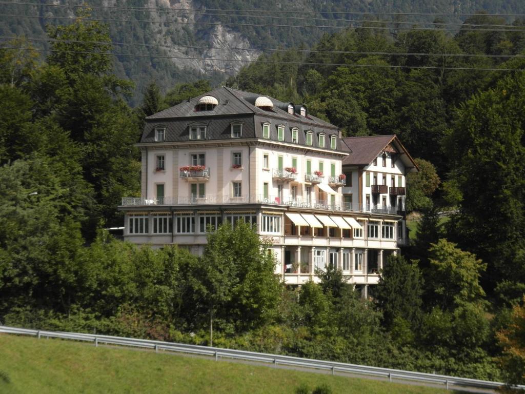 a large building on the side of a hill at Budget Waldhotel Unspunnen in Interlaken