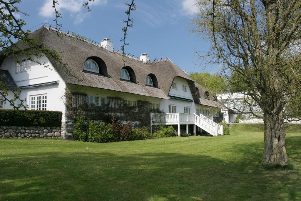 ein großes weißes Haus mit einem Walmdach in der Unterkunft Comwell Borupgaard in Snekkersten